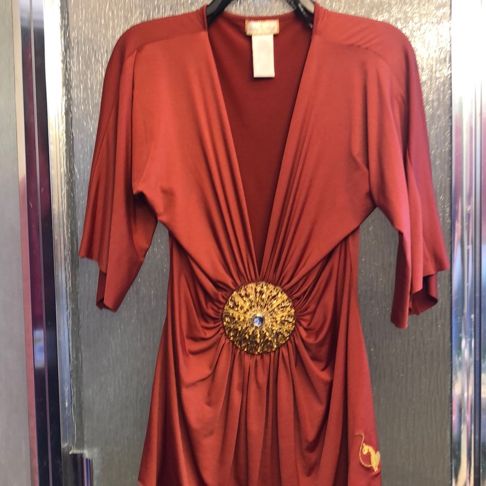 Baby Phat rust orange colored blouse with medallion in center. Size small
